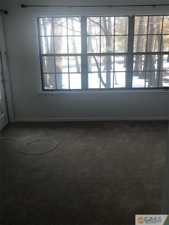 2702 Ridgefield Court, Unit 2702 Helmetta, NJ 08828 - Photo 5 of 8 an empty room with a empty space and windows