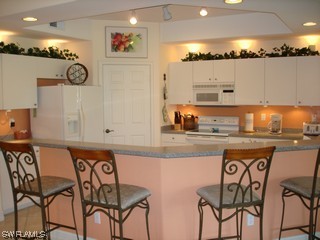 21743 Sound Way, Unit 101 Estero, FL 33928 - Photo 2 of 8 a kitchen with a table and chairs in it