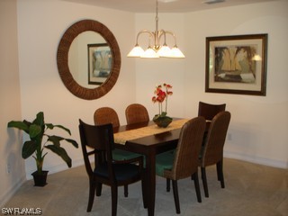 21743 Sound Way, Unit 101 Estero, FL 33928 - Photo 4 of 8 a view of a dining room with furniture and chandelier