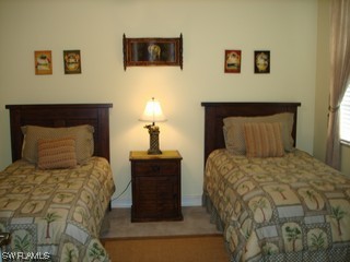 21743 Sound Way, Unit 101 Estero, FL 33928 - Photo 7 of 8 a bedroom with a bed and a night stand