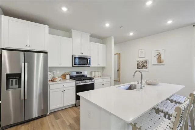 a kitchen with stainless steel appliances a sink stove refrigerator and cabinets