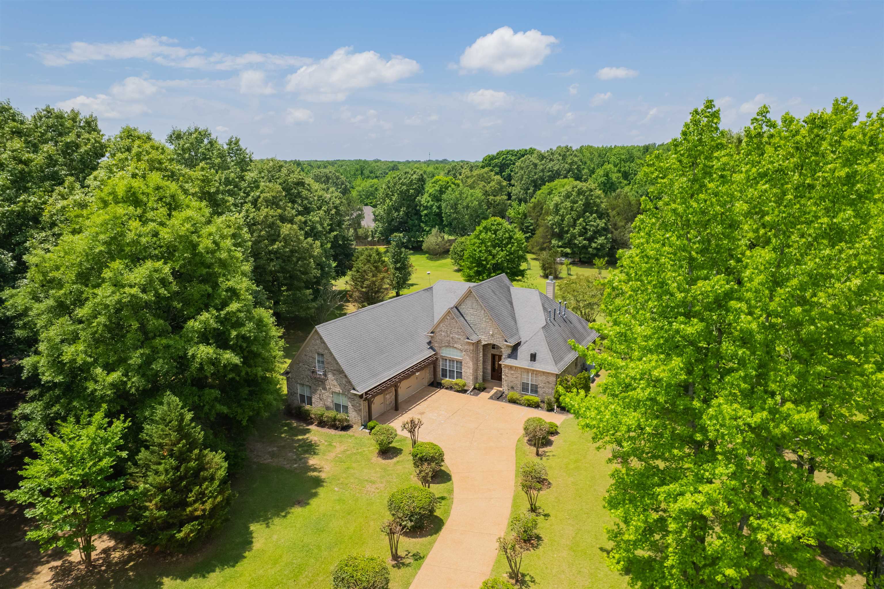 5035 Brian Ridge Road Arlington, TN 38002 - Photo 36 of 40 Expansive property featuring a stone and brick exterior, a paved winding driveway, and a dark shingle roof