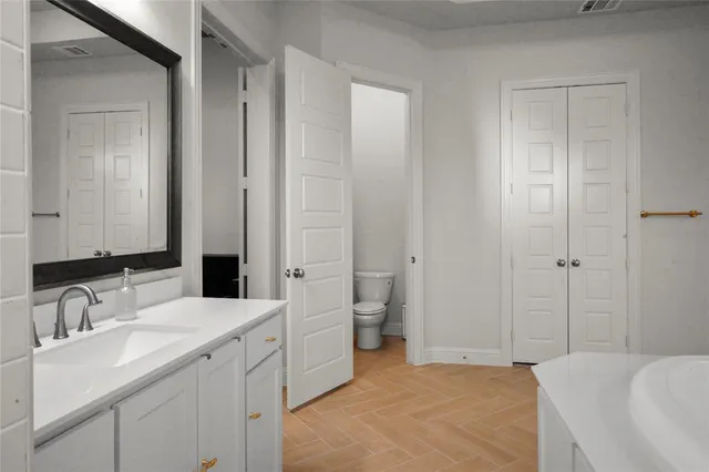 a bathroom with a tub sink and mirror