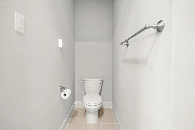 a white toilet sitting next to a white wall
