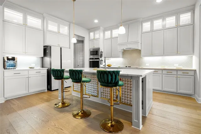 a kitchen with stainless steel appliances kitchen island granite countertop a stove a sink and a refrigerator