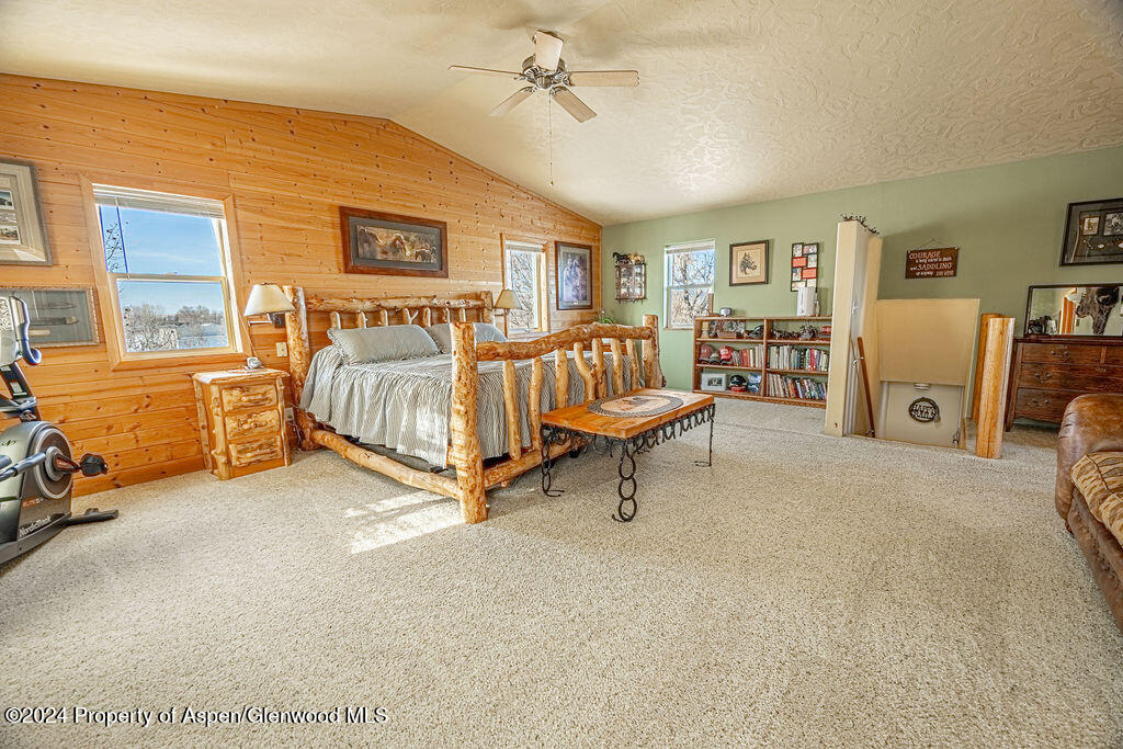 1020 Thompson Way Craig, CO 81625 - Photo 21 of 92 a spacious bedroom with a bed and a chandelier