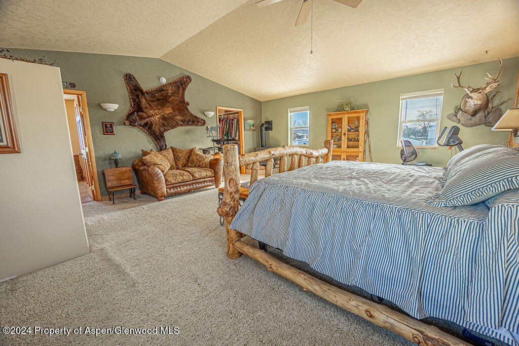 1020 Thompson Way Craig, CO 81625 - Photo 23 of 92 a bed sitting in a spacious bedroom next to a window and a flat screen tv