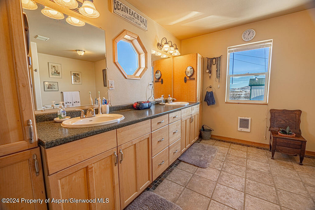1020 Thompson Way Craig, CO 81625 - Photo 25 of 92 a spacious bathroom with a double vanity sink a mirror and a