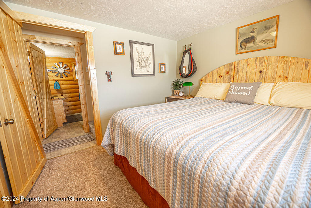 1020 Thompson Way Craig, CO 81625 - Photo 29 of 92 a bedroom with a bed and wooden floor