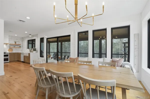 a dining room with furniture a chandelier and wooden floor