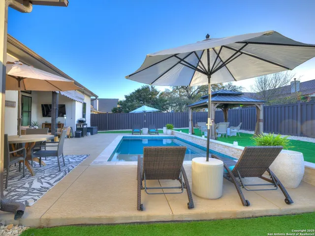 a view of swimming pool with outdoor seating and a yard