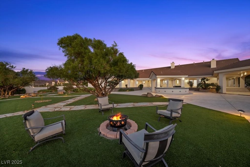 640 Quail Covey Road Henderson, NV 89002 - Photo 64 of 75 View of grassy yard featuring an outdoor fire pit and a patio area