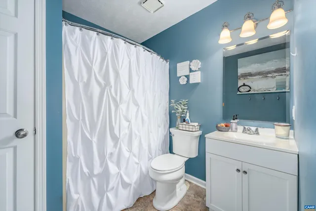 a bathroom with a sink vanity mirror and toilet
