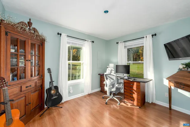 a view of a workspace with furniture and a window