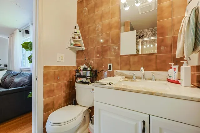 a bathroom with a granite countertop toilet sink and mirror