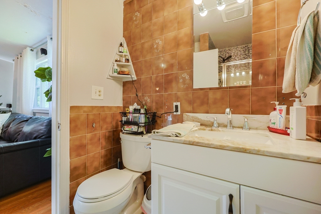7 Jackson Court, Unit B Natick, MA 01760 - Photo 14 of 28 a bathroom with a granite countertop toilet sink and mirror