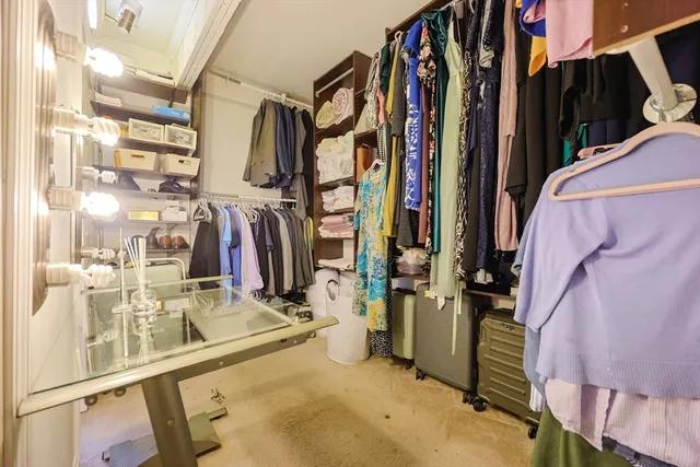 a view of walk in closet with clothes and shoes