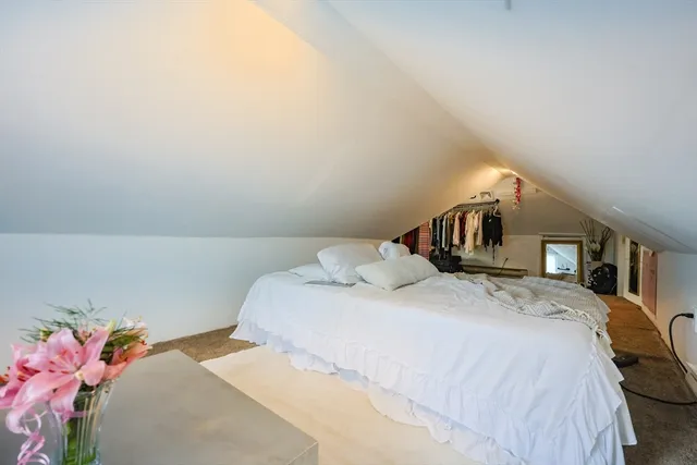 a bedroom with a bed and a potted plant