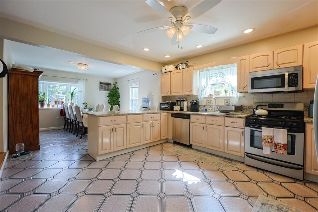 7 Jackson Court, Unit B Natick, MA 01760 - Photo 4 of 28 a kitchen with stainless steel appliances kitchen island granite countertop a refrigerator a stove top oven a sink a counter top space and cabinets