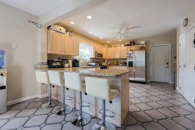 a kitchen with stainless steel appliances kitchen island granite countertop a refrigerator and a stove top oven