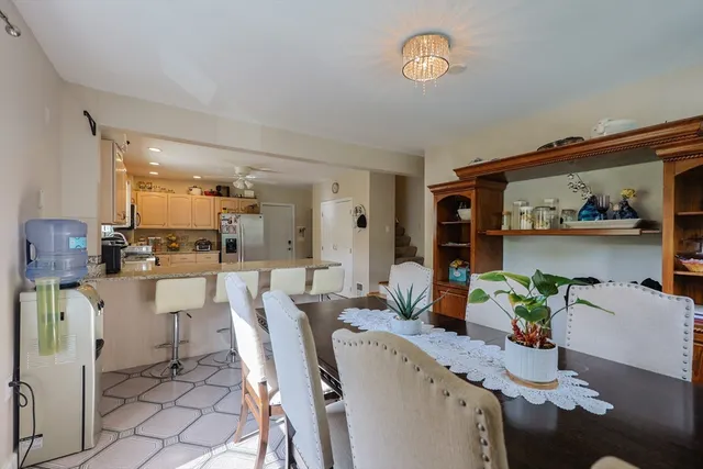a dining room with furniture a potted plant and a painting
