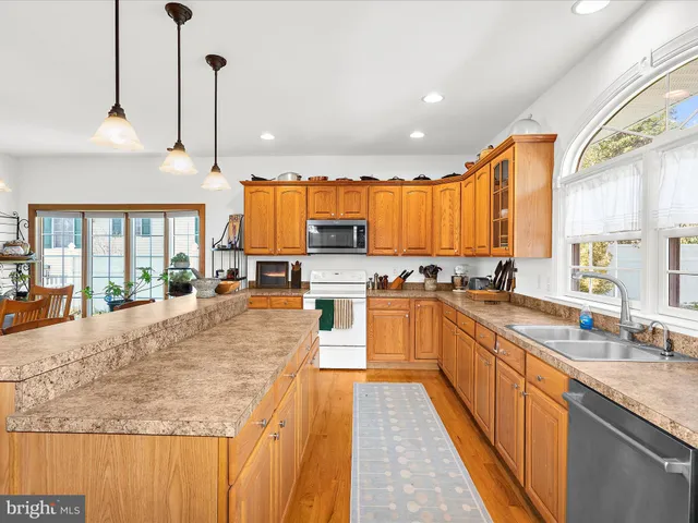 a large kitchen with granite countertop a large counter top appliances a sink and cabinets