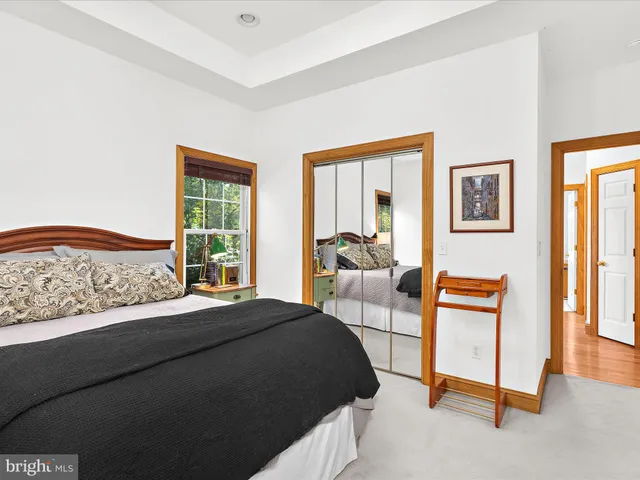 a bedroom with a bed and a couch next to a window