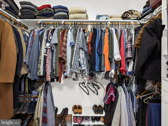 a view of walk in closet with clothes