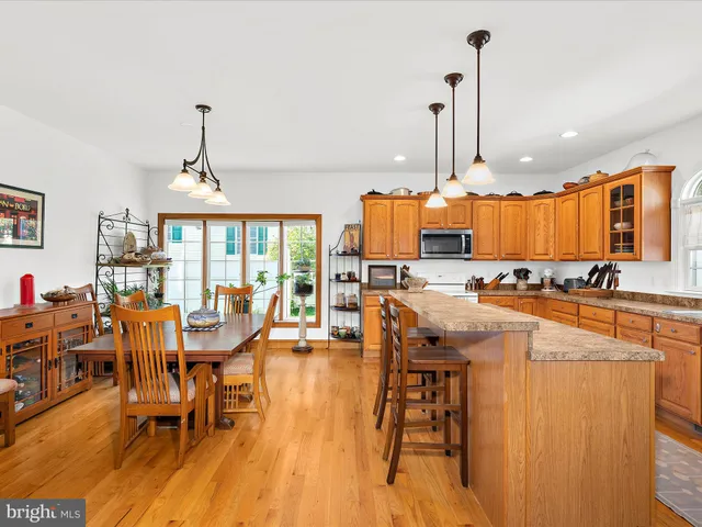 a view of a dining room and livingroom with furniture wooden floor a chandelier