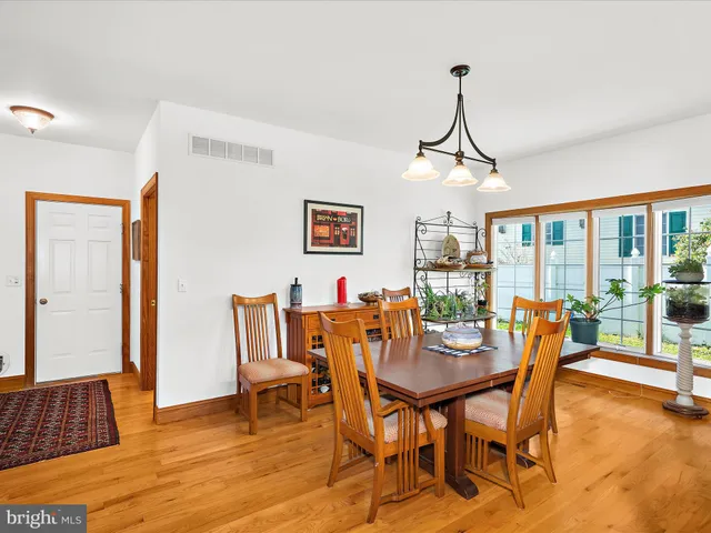 a dining room with furniture a chandelier and wooden floor