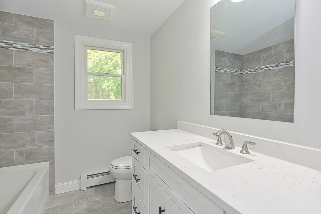 31 Clarkson Drive Walpole, MA 02081 - Photo 13 of 36 a bathroom with a toilet a sink a mirror and a bathtub