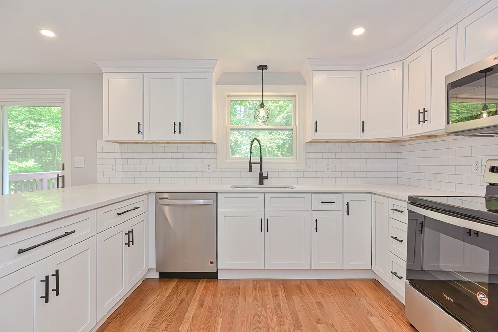 31 Clarkson Drive Walpole, MA 02081 - Photo 4 of 36 a kitchen with white cabinets white appliances wooden floor and a window