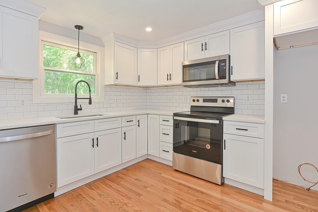 31 Clarkson Drive Walpole, MA 02081 - Photo 6 of 36 a kitchen with white cabinets stainless steel appliances and wooden floor