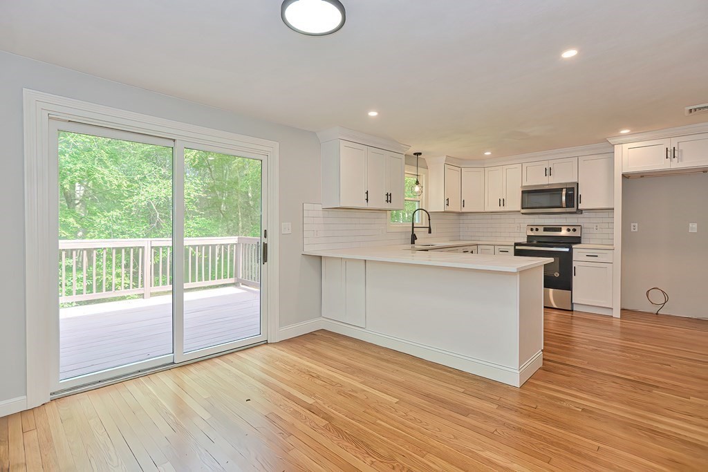 31 Clarkson Drive Walpole, MA 02081 - Photo 7 of 36 a kitchen with wooden floors and white stainless steel appliances