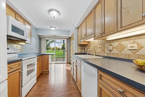 a kitchen with stainless steel appliances granite countertop a sink stove and cabinets
