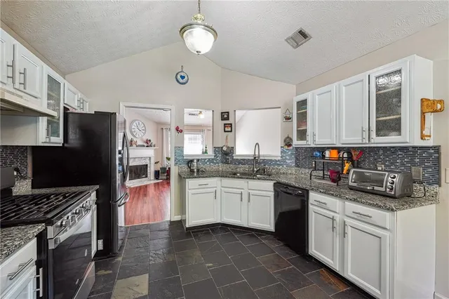 a kitchen with stainless steel appliances granite countertop a stove sink and cabinets