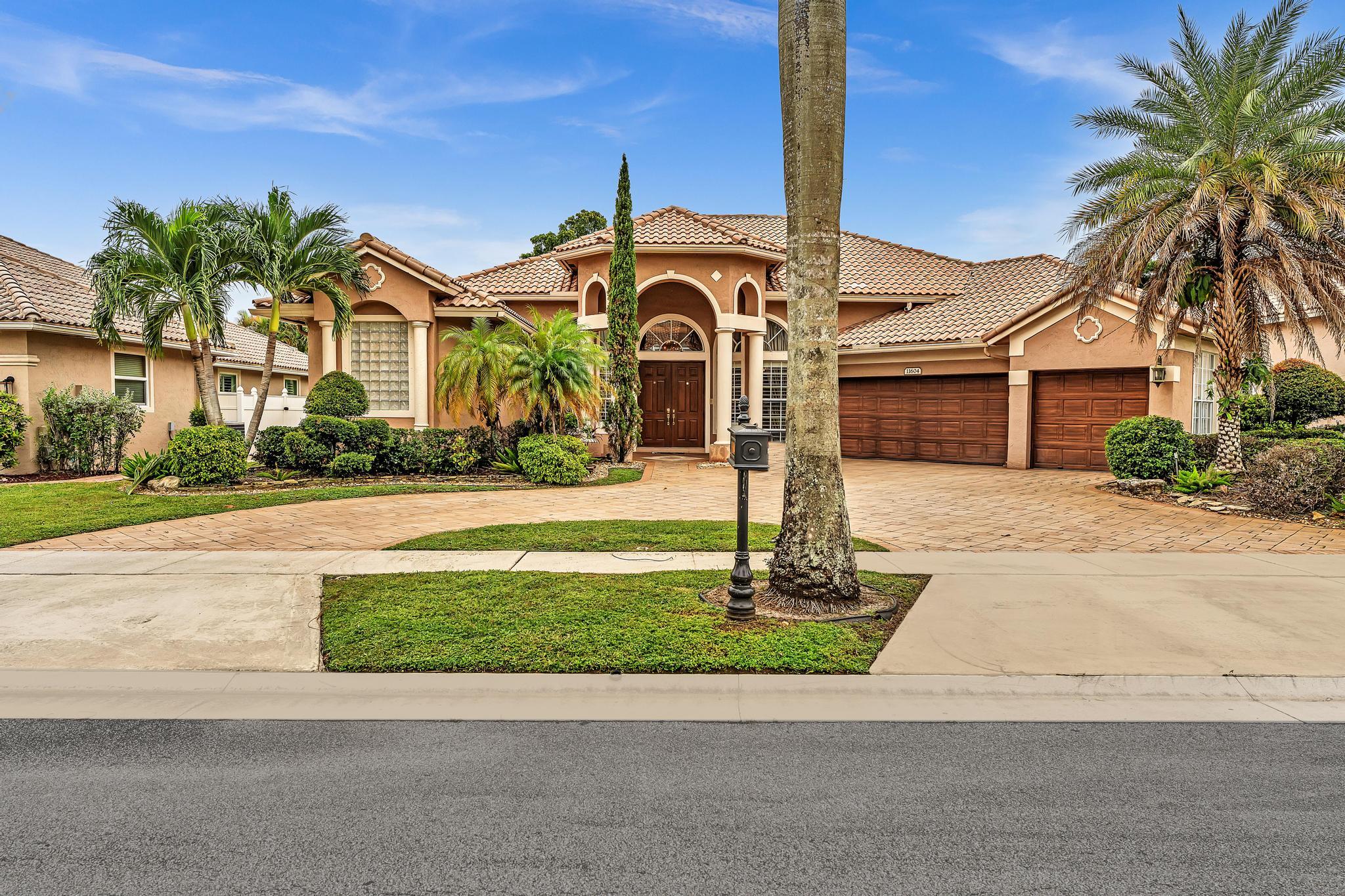 11604 Kensington Court Boca Raton, FL 33428 - Photo 1 of 81 a front view of a house with a garden and plants