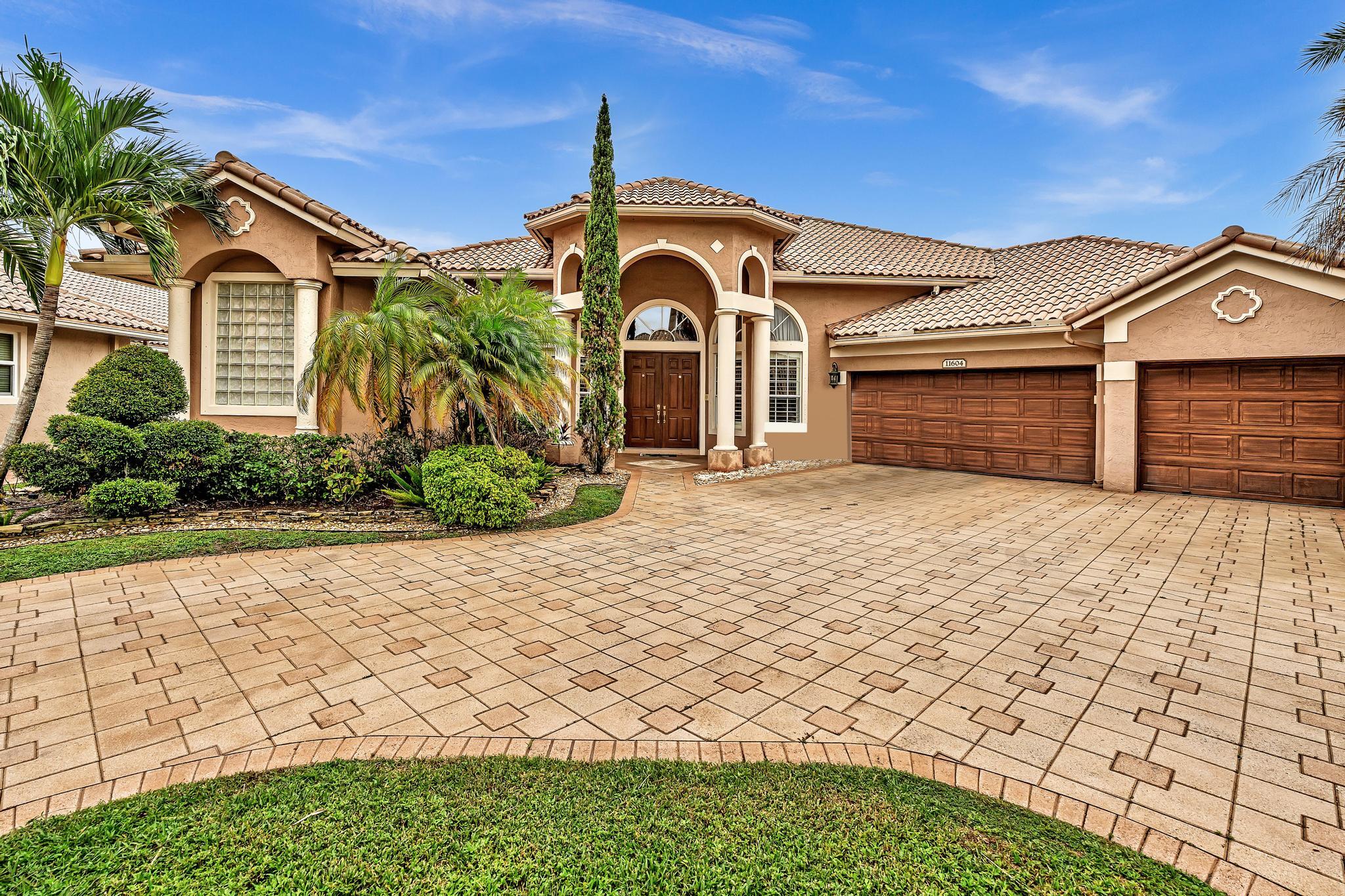 11604 Kensington Court Boca Raton, FL 33428 - Photo 3 of 81 a front view of a house with a yard and potted plants