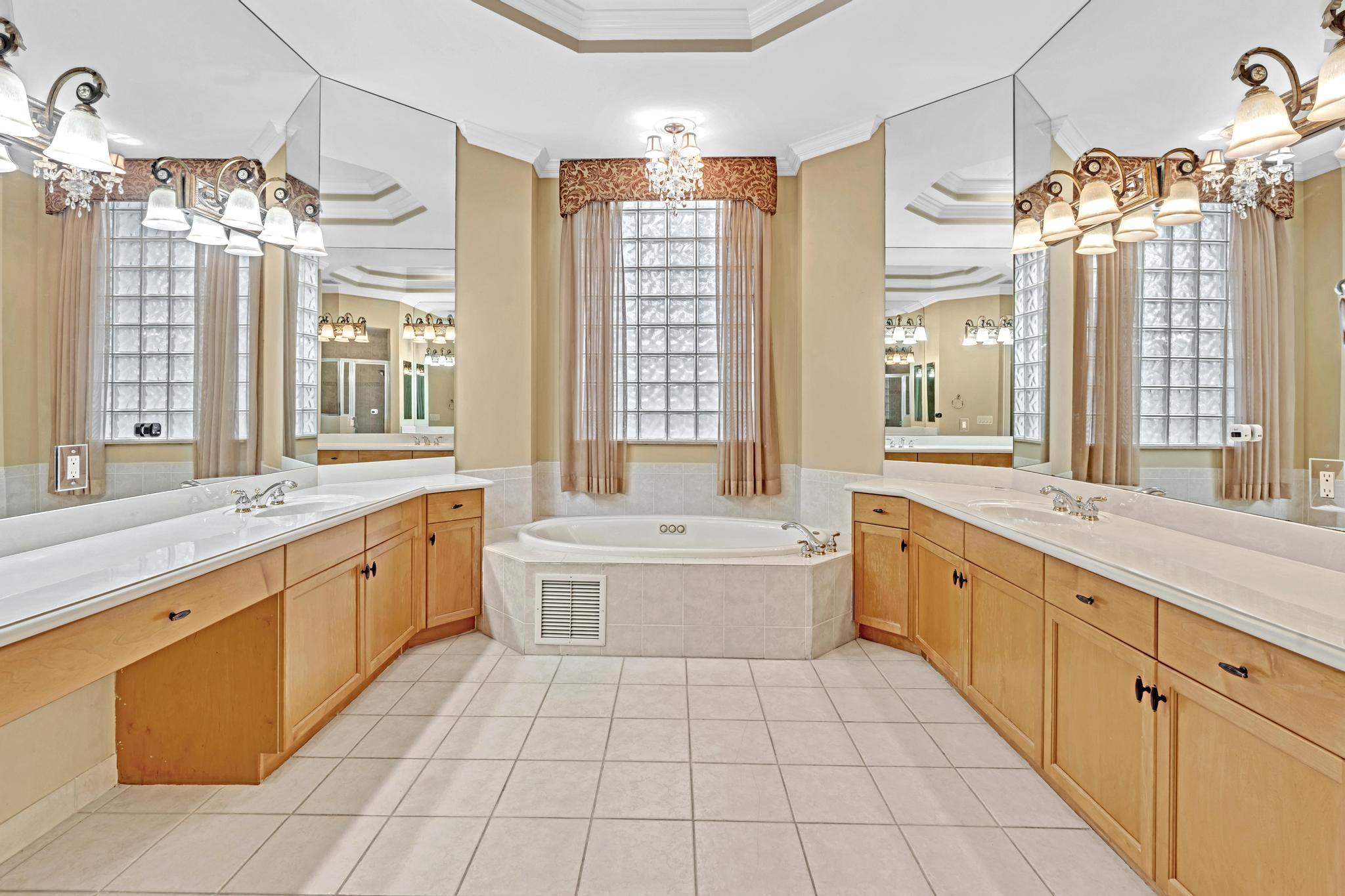 11604 Kensington Court Boca Raton, FL 33428 - Photo 35 of 81 a large white bathroom with a large tub sink shower and mirror