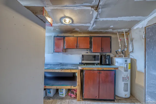 a kitchen with kitchen island granite countertop a sink cabinets and stainless steel appliances