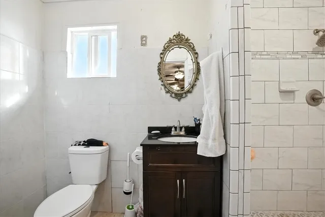 a bathroom with a toilet a sink and mirror