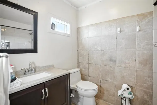 a bathroom with a granite countertop sink toilet and a mirror