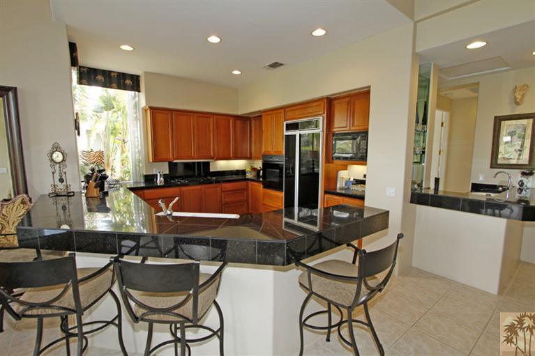 231 Loch Lomond Road Rancho Mirage, CA 92270 - Photo 9 of 25 a kitchen with stainless steel appliances kitchen island granite countertop a sink and cabinets