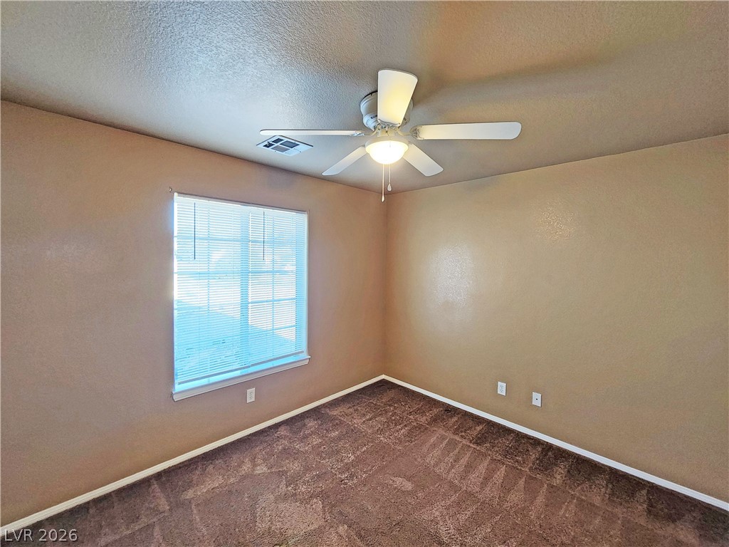 3680 Ravine Avenue Pahrump, NV 89048 - Photo 19 of 28 Spare room featuring a textured ceiling, ceiling fan, baseboards, dark colored carpet, and visible vents