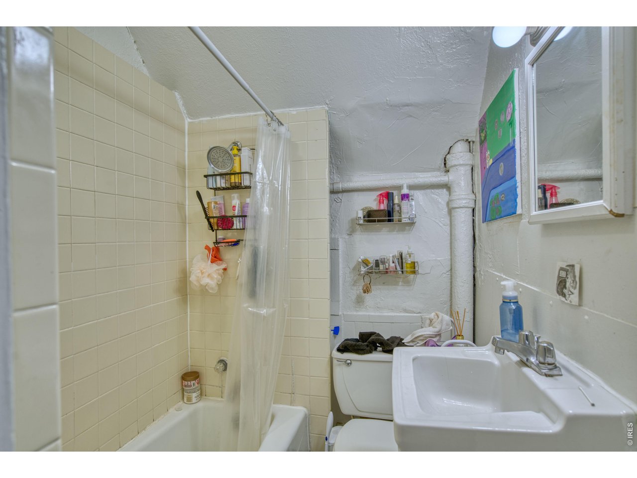 1034 Spruce Street Boulder, CO 80302 - Photo 8 of 17 a bathroom with a sink a mirror and a shower