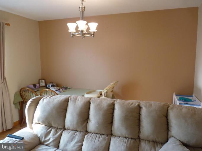 17420 Hughes Road Poolesville, MD 20837 - Photo 14 of 21 a bed sitting in a bedroom next to a chandelier