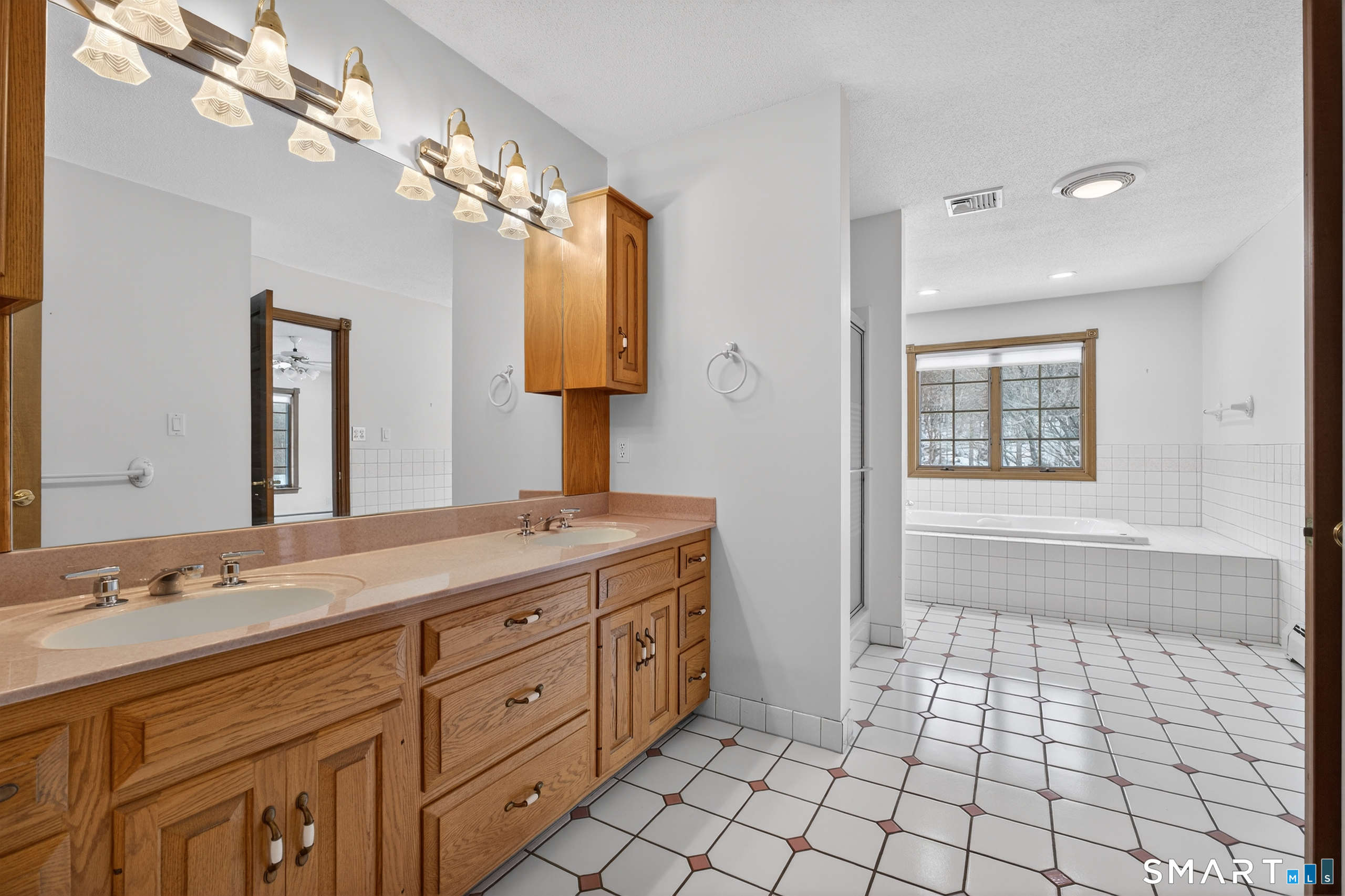 61 Edwards Road Bethany, CT 06524 - Photo 16 of 40 a spacious bathroom with a granite countertop sink a mirror and a shower