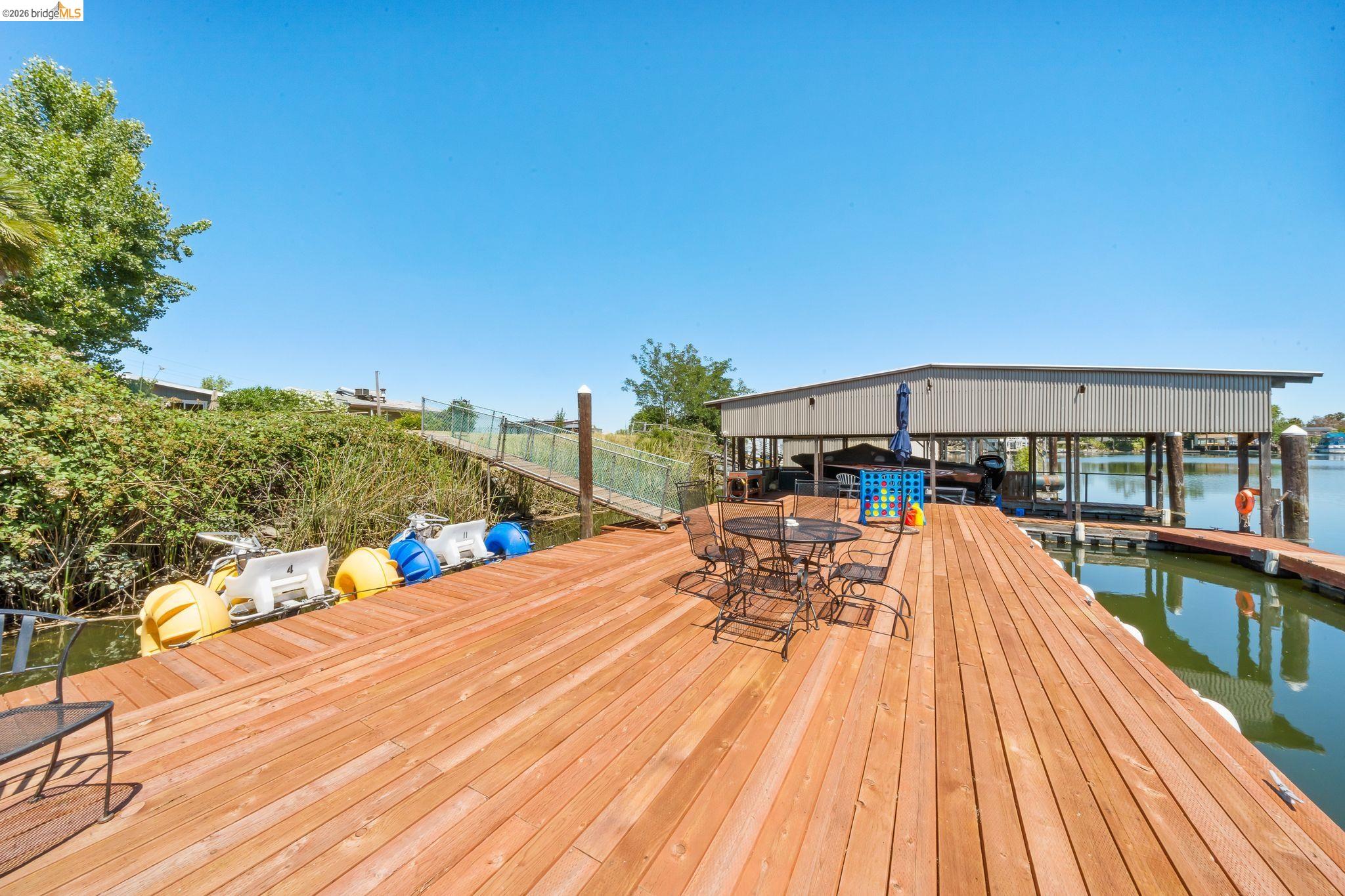 1704 Taylor Road Bethel Island, CA 94511 - Photo 56 of 73 Wood-plank dock featuring a built-in boat house, covered boat slips, and direct water access