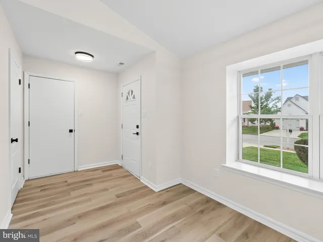 a view of a room with wooden floor and a window