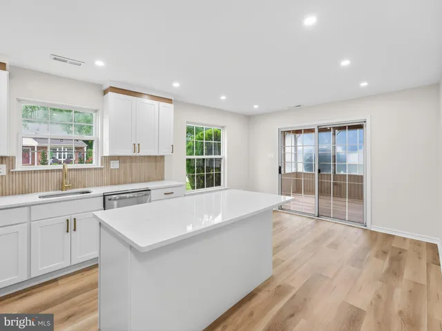 a large white kitchen with a large window